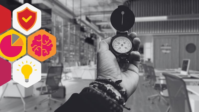 a hand holds a compass in an office space