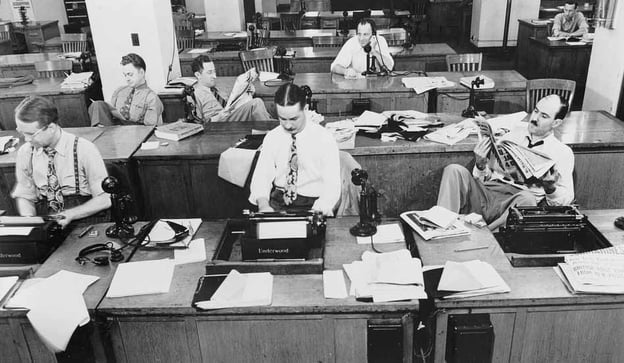 Old timey office with men at their aligned desks