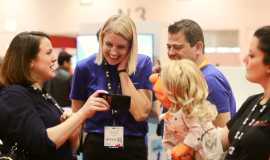 Photograph of a female puppet interacting with a group of humans